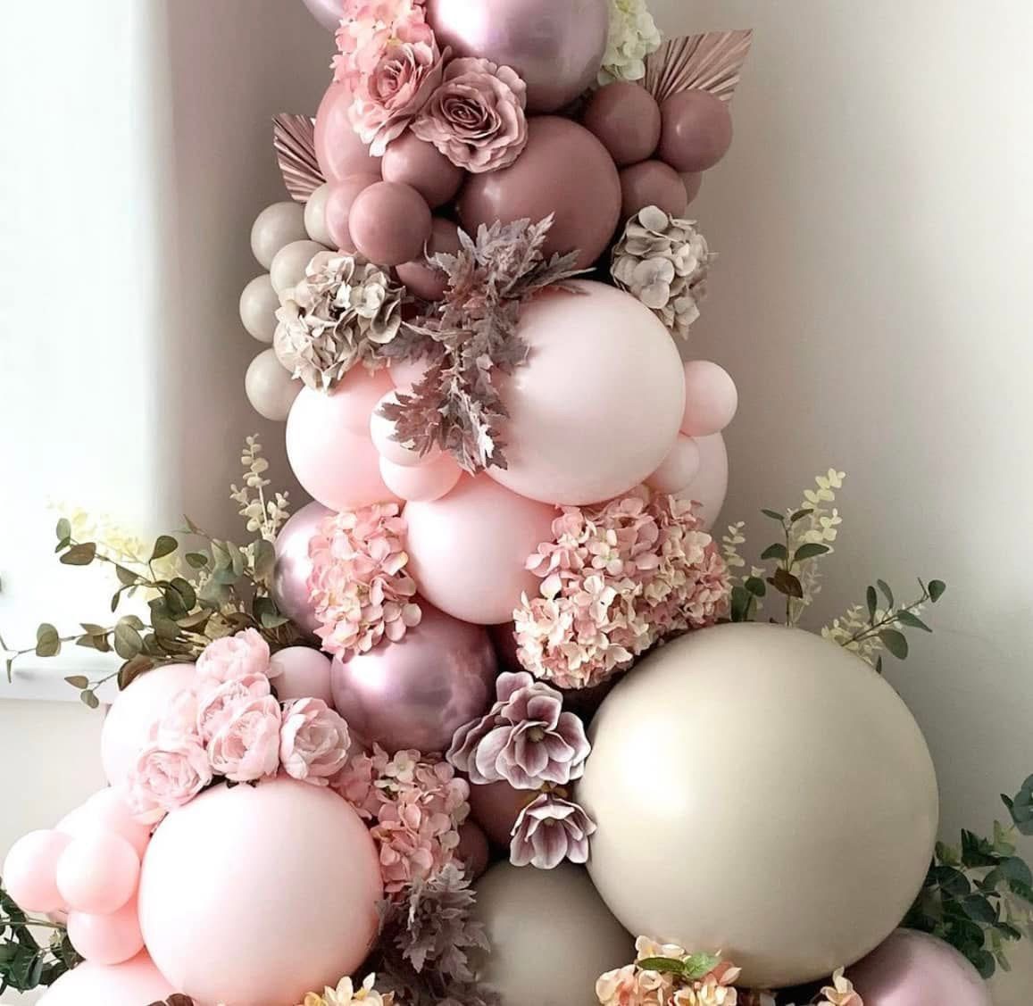 Close-up of a blush and nude organic balloon installation with florals