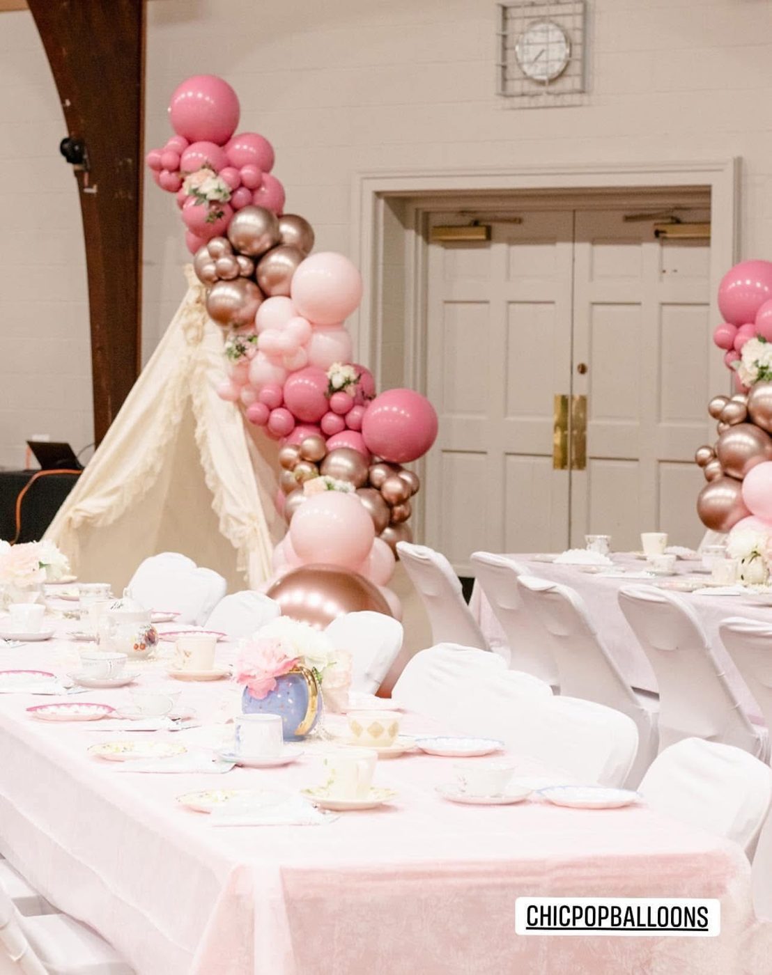 Pink and white balloon garland over a decorated party table