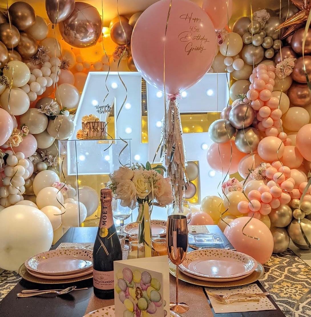 Warm neutral balloon garland surrounding an elegant party table