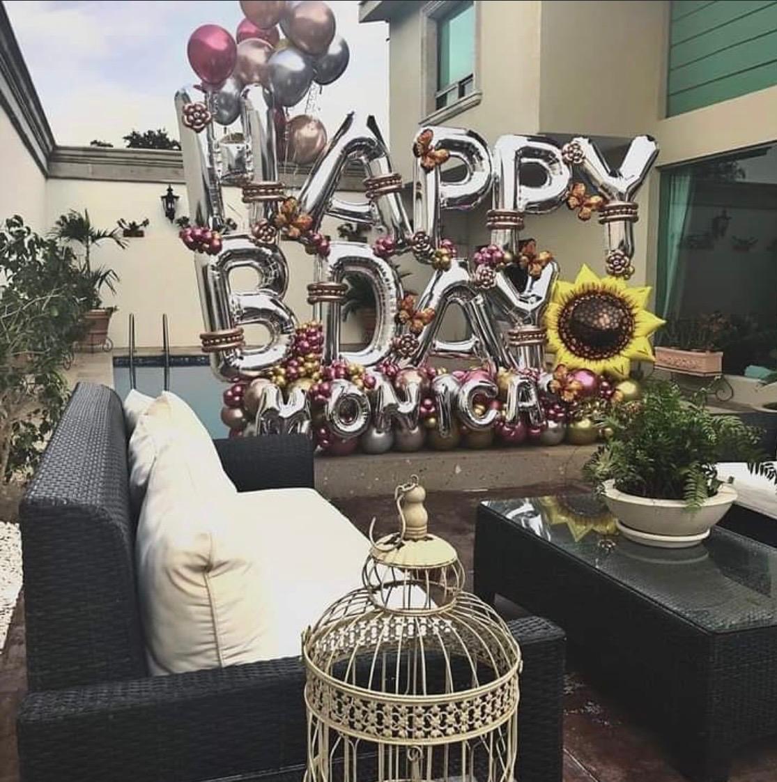 Metallic birthday balloon arrangement in an outdoor lounge