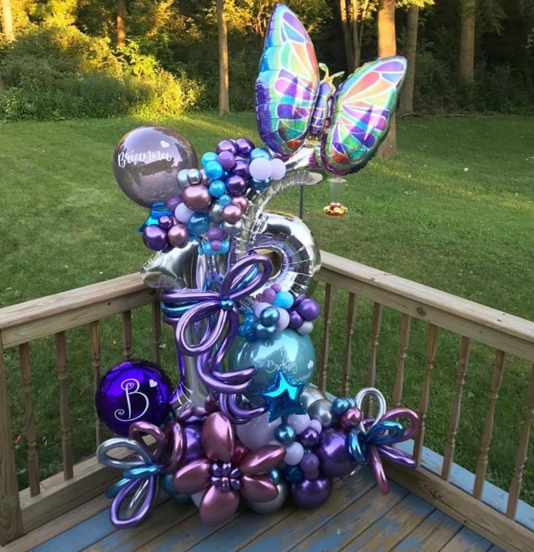 Purple and blue butterfly balloon arrangement outdoors