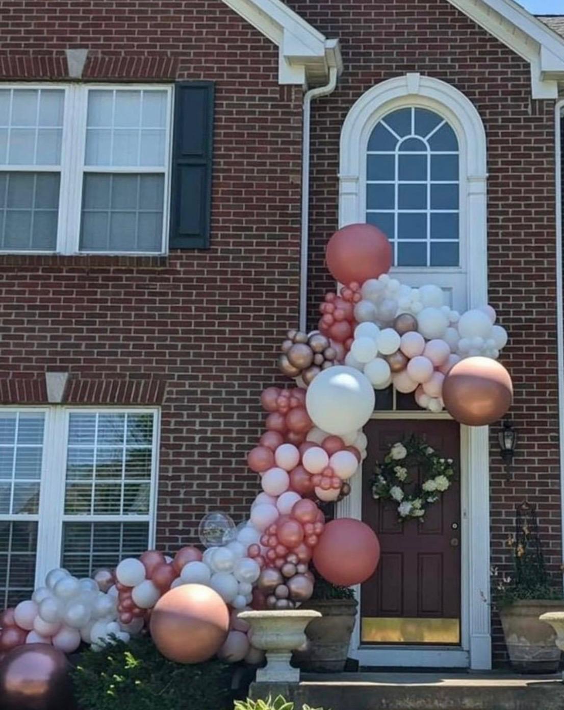Blush and ivory balloon garland decorating a front entrance