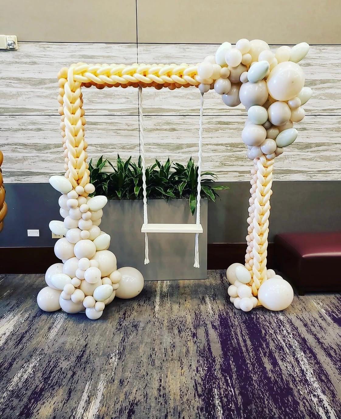 White and gold balloon arch framing a display table