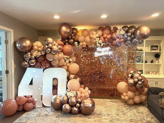 Rose gold and blush balloon installation with a sequin backdrop for a 40th birthday celebration